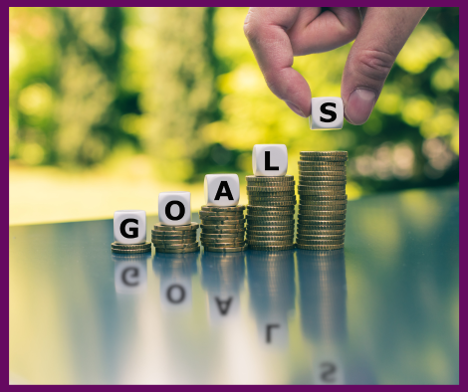 Goals written on dice stacked on coins